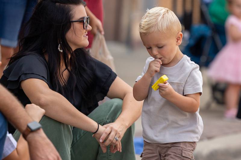 Child holds candy thrown from parade on Sunday, Aug 31, 2025 at the Labor Day parade on Main Street in Streator.