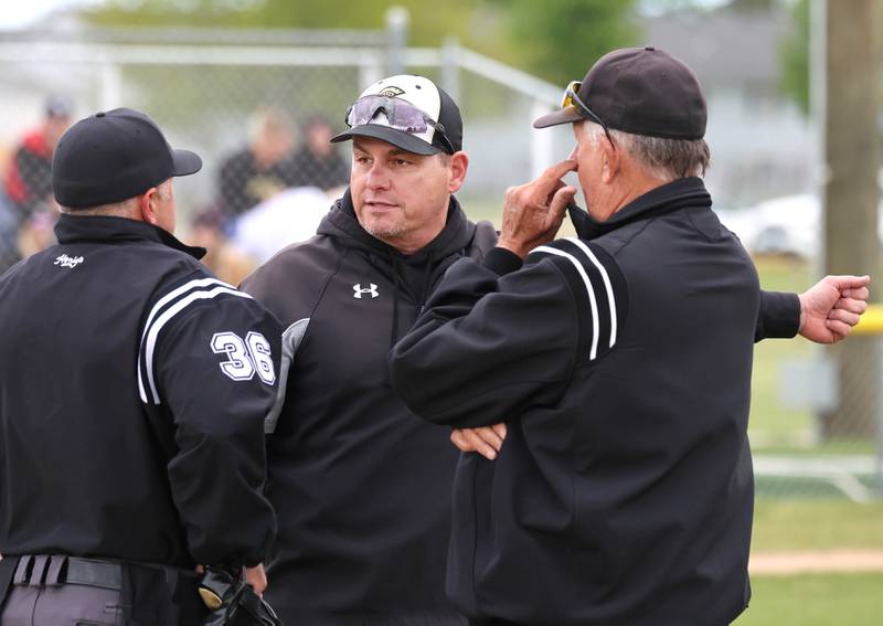 Sycamore head coach Jason Cavanaugh talks to the umpires after a questionable tag play Wednesday, May 13, 2026, during their game against Morris at the Sycamore Community Sports Complex.