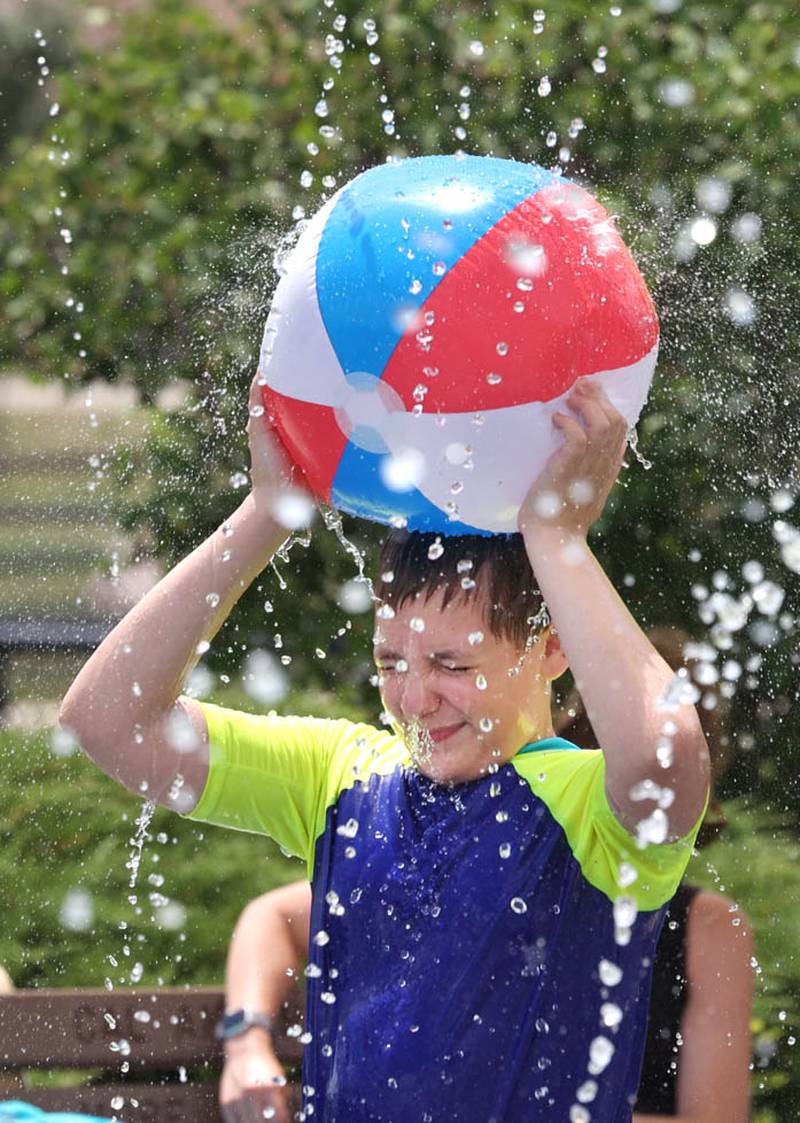 Brantley Fraedrich, 11, from Sycamore keeps some of the water off his head Thursday, June 20, 2024, at Splash Fountain Splashpad at the Sycamore Park District’s Legacy Campus on Airport Road. High temperatures have been over 90 degrees every day this week making splash pads and pools very popular destinations.