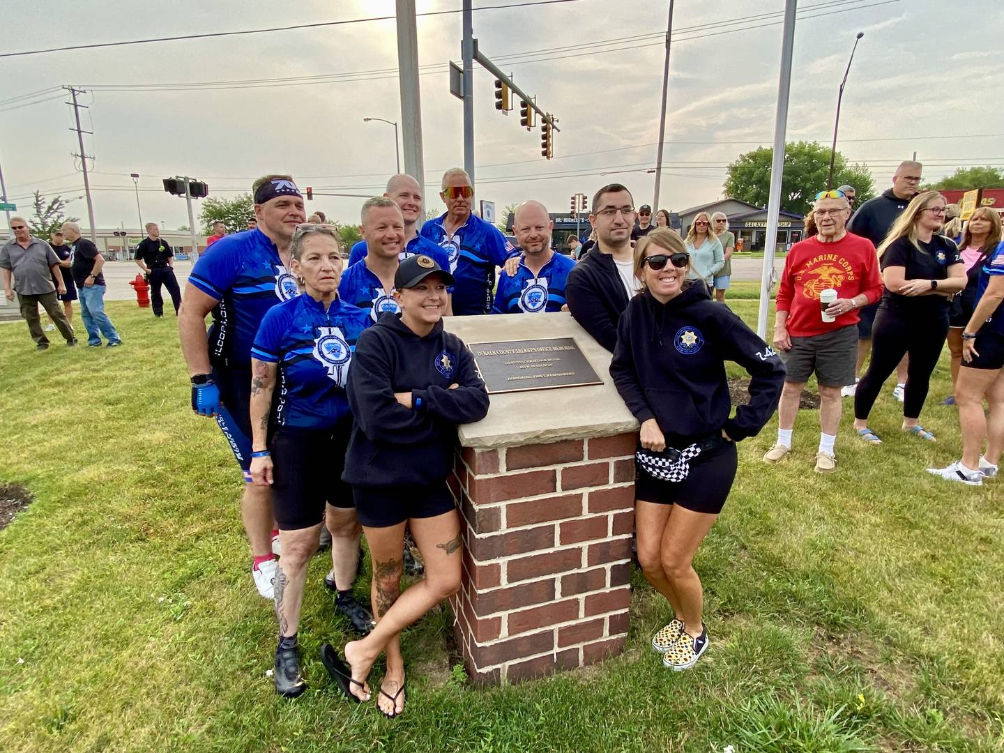 Members of the group supporting the late DeKalb County sheriff's deputy Christina Musil, 35, pose next to her memorial at the DeKalb Memorial Wall in Sycamore on Sunday, July 13, 2025. Musil was honored for the 2025 Cycle Across Illinois. Riders pictured include DeKalb County Sheriff Andy Sullivan, his brother Huntley Police Sgt. Scott Sullivan, DCSO deputy Tyler Rogman, retired DeKalb police officer Fred Busby, DeKalb County prosecutor Regna, DCSO corrections officers Lexi Frankenberry and Sarah Westlake and Musil’s mother Diane Caporaso.