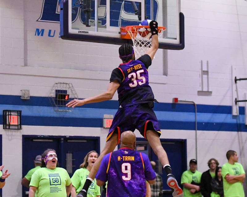 Harlem Wizard player Sky-Rises jumps over teammate A-train during the game against the Downers Grove Staff on Sunday Jan. 19, 2025, held at Downers Grove South High School.