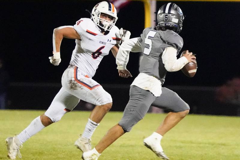 Oswego’s Mikey Claycombe (6) flushes Oswego East's Niko Villacci (5) out of the pocket during a football game at Oswego East High School on Friday, October 25, 2024.