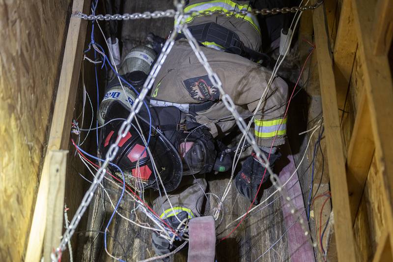 A cadet crawls through a wire crossed tight space Saturday, March 15, 2025, during self contained breathing (SCB) training in Amboy. The cadets were following a line of hose through enclosed spaces while wearing their oxygen tanks.