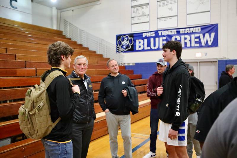 Iowa Hawkeye football coaches Kirk Ferentz and Seth Wallace visit with Princeton's Teegan Davis (left) and Noah LaPorte (right) after Tuesday's basketball game at Prouty Gym. Davis has signed to play football for the Hawkeyes this fall.
