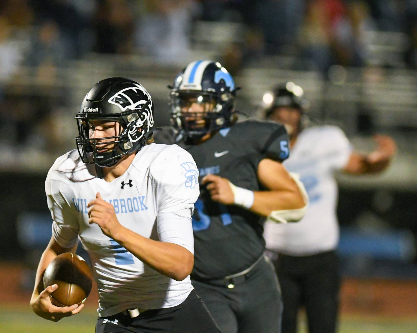 Willowbrook’s quarterback Arthur Palicki, left, runs the ball during the first half of the game as they travel to Downers Grove South on Friday Sep. 15, 2023.