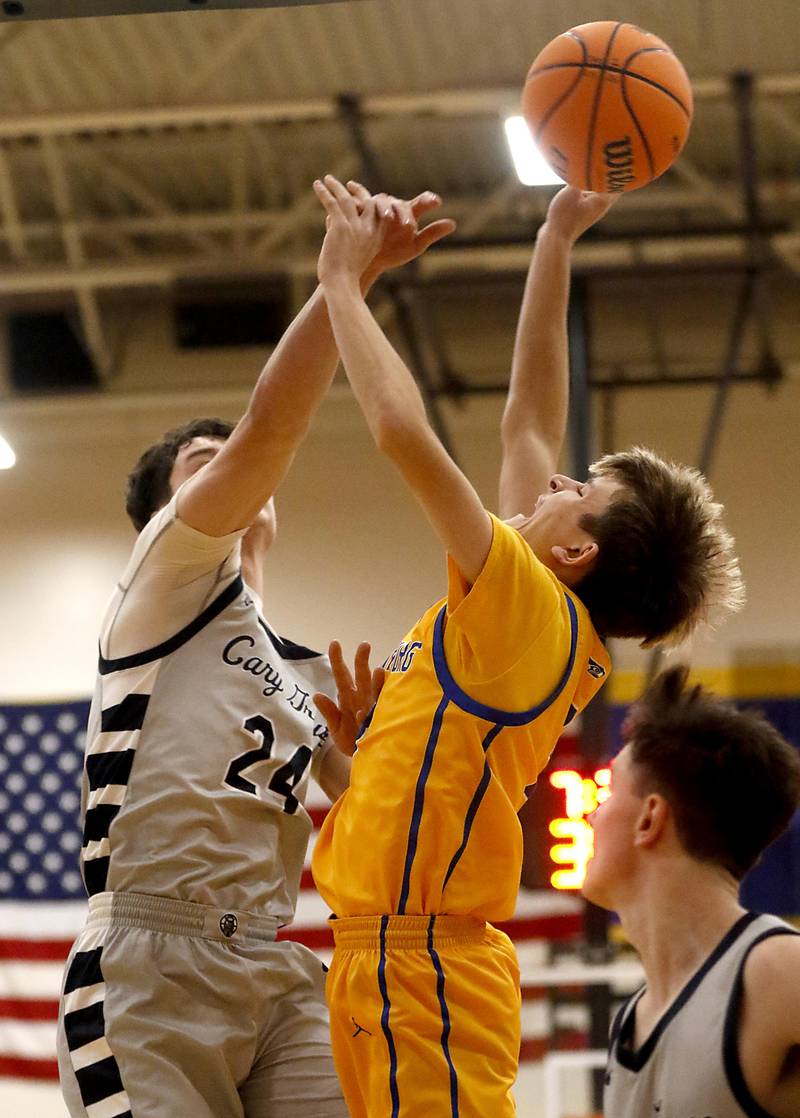 Johnsburg's Trey Toussaint tries to shoot the ball over Cary-Grove's Brady Bauer during a Johnsburg Thanksgiving Tournament boys basketball game on Monday, Nov. 24, 2025, at Johnsburg High School.