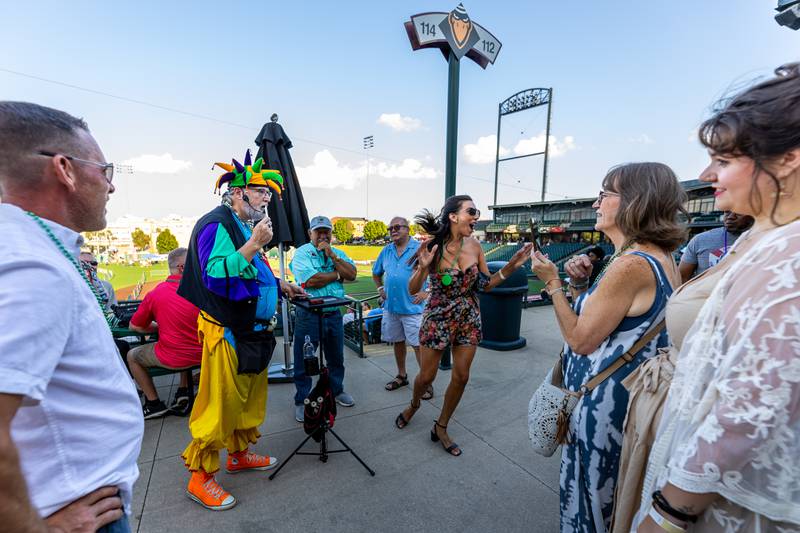 Magician Keith Cobb shows Lorraine Guerrero-Neumayer her card during New Orleans North Festival held at the Joliet Slammers Stadium on Aug. 16, 2024.