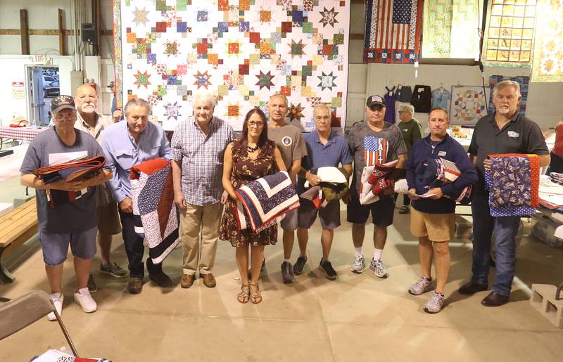 (From left) Veterans Leonard Wasilewski, Frederick Best, Dr. Levisay, Frederick West, Amanda Gibson, Larry Dzierzynski, Michael Brown, Joseph Ruggerio, Mark Mautino and Dan Smith pose for a photo during the Quilt of Valor ceremony at the Tribute to Veterans on Wednesday, Aug. 20, 2025 at the Bureau County Fair in Princeton. Eleven Veterans in total received their quilts. Adam Peterson was absent.