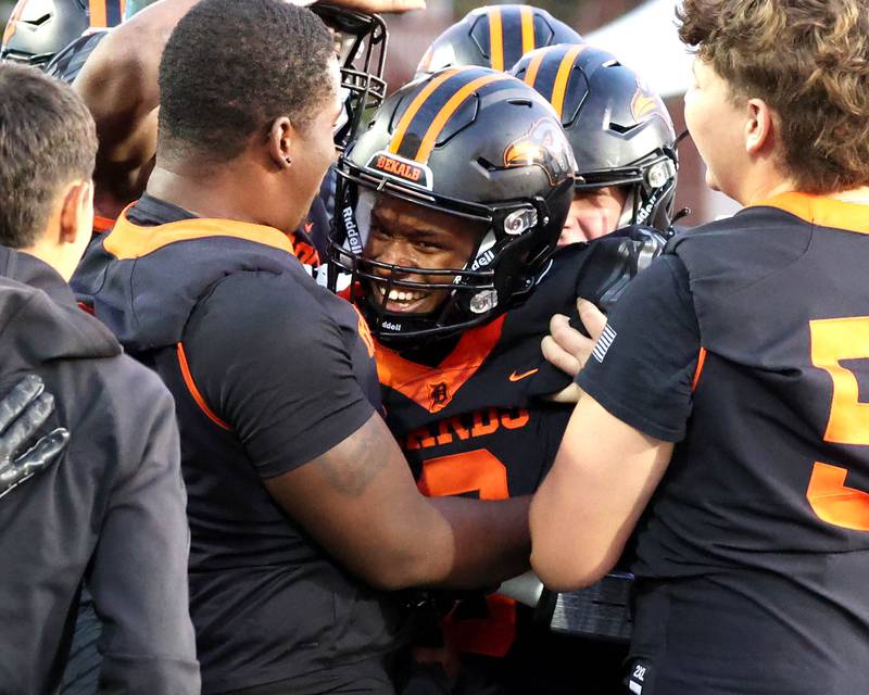 The DeKalb bench mobs DeKalb's Billy Miller after he caught a touchdown pass against Sycamore Friday, Aug. 30, 2024, during the FNBO Challenge at Huskie Stadium at Northern Illinois University.