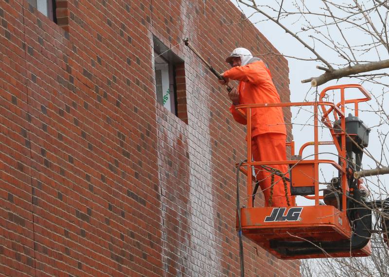 A worker sprays off  bricks on the exterior wall of the La Salle-Peru Township High School's new Agriculture Center on the southeast corner of Sixth and Creve Coeur streets on Wednesday, April 1, 2026 in La Salle.