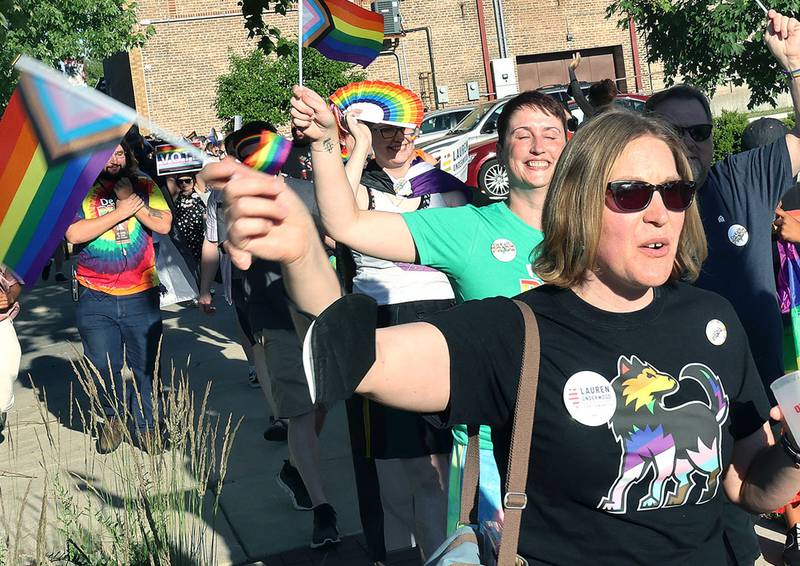 Participants march down the sidewalk on East Locust Street Thursday, June 23, 2022, during a parade to celebrate Pride month in DeKalb. The function included a short parade through downtown and a showing of the movie “Tangerine,” with a panel discussion afterwards at the Egyptian Theatre.