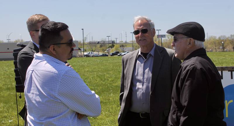 In the foreground, former Dixon mayor Li Arellano Jr. and new Mayor Glen Hughes speak with hotel developer Al Hill, at right, on Wednesday, May 3, 2023, prior to a groundbreaking for a Tru by Hilton in the field behind the Super 8. Partially obscured at left is Tom Demmer of the  Lee County Industrial Development Association.