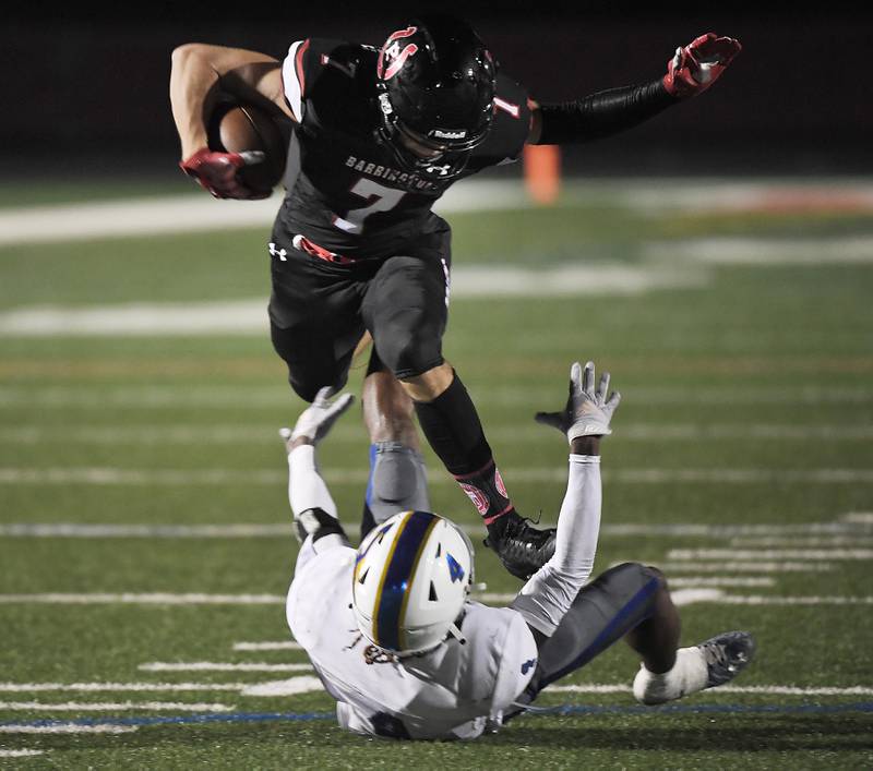 Barrington’s Matt Marusich runs over Warren’s XZavion Montgomery after making a catch at Barrington High School Friday, August 25, 2023.