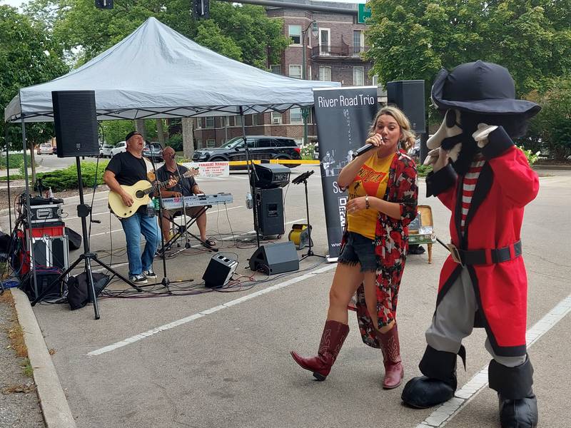 Sudsy, the Ottawa Pirates mascot, dances with River Road Trio as they perform Wednesday, Aug. 2, 2023, during Welcomeburger in Ottawa.