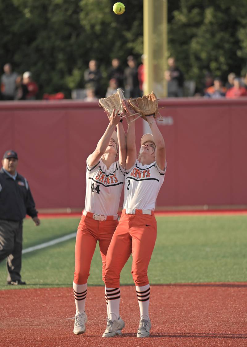 St. Charles East third baseman Holly Smith and shortstop Addison Wolf collide as Wolf catches a pop up by Barrington’s Liana Maggioin an IHSA Class 4A supersectional softball game in Barrington on Monday, May 9, 2025.