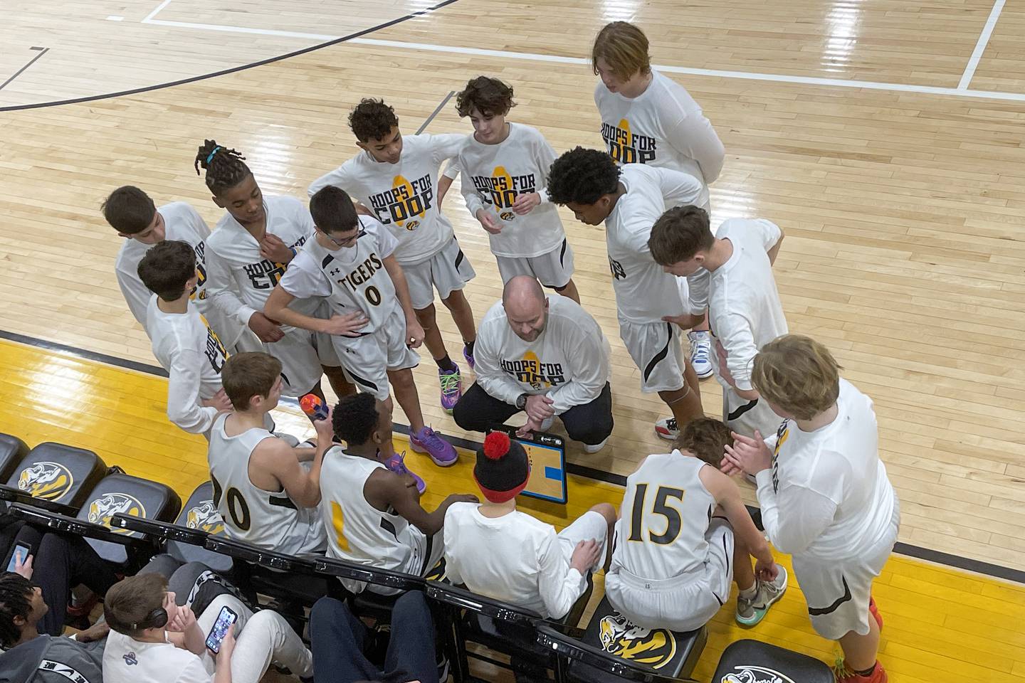 Josh McDaniel, fifth grade teacher and basketball coach at Liberty Intermediate School in Bourbonnais, center, informs player Cooper Freedlund, seated second from right, that he will be scoring a basket during the game. Freedlund remained on the team as he battled a cancer diagnosis.