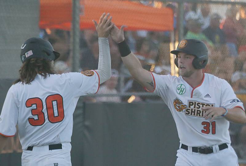 Pistol Shrimp's Garry Maynard (31) hi-fives teammate Alex Rakas (30) after scoring a run during the Eastern Conference Championship game on Tuesday, Aug, 9 2022 at Schweickert Stadium in Veterans Park in Peru.