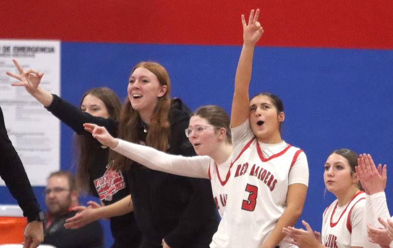 Huntley’s Red Raiders celebrate an Aubrina Adamik three-pointer against Hononegah in girls basketball at Dundee-Crown High School in Carpentersville on Tuesday, November 25, 2025.