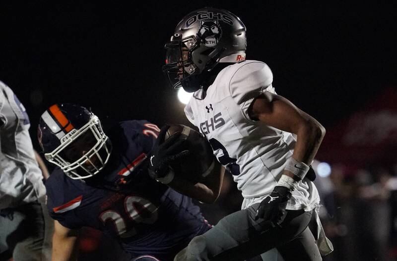 Oswego East's Andre Cobige Jr. (3) carries the ball against Oswego during a football game at Oswego High School on Friday, Oct. 20, 2023.
