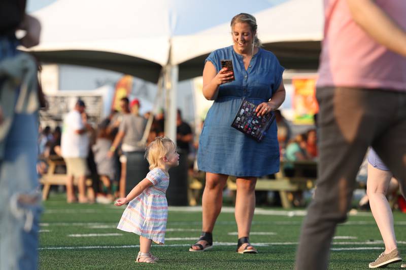 Jessica Boyne takes photos of her daughter, Charlotte, dancing at the Taste of Joliet on Friday, June 23, 2023.