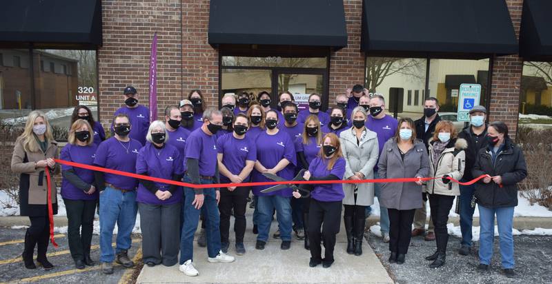 Peter Lineal, founder of Plum Grove, along with Kara Lineal, president and chief marketing officer, cut the ribbon to celebrate the company's new location in Cary. They are joined by the staff of Plum Grove Inc. and the staff and board members of the Cary-Grove Area Chamber of Commerce.