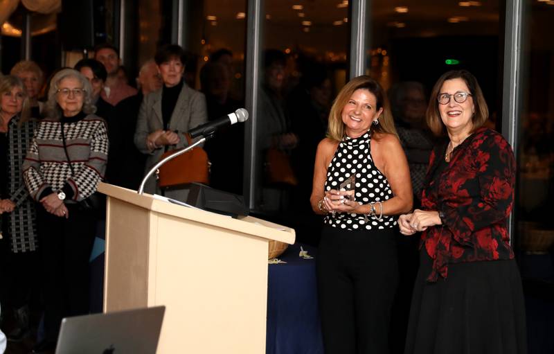 Kristie Dienst (left) watches a video in her honor with Geneva Chamber of Commerce Interim Chairman Martha Sanchez after being announced as the 2023 Geneva Chamber of Commerce Wood Award winner during the chamber’s annual dinner and awards at Riverside Receptions in Geneva on Thursday, Nov. 2, 2023.