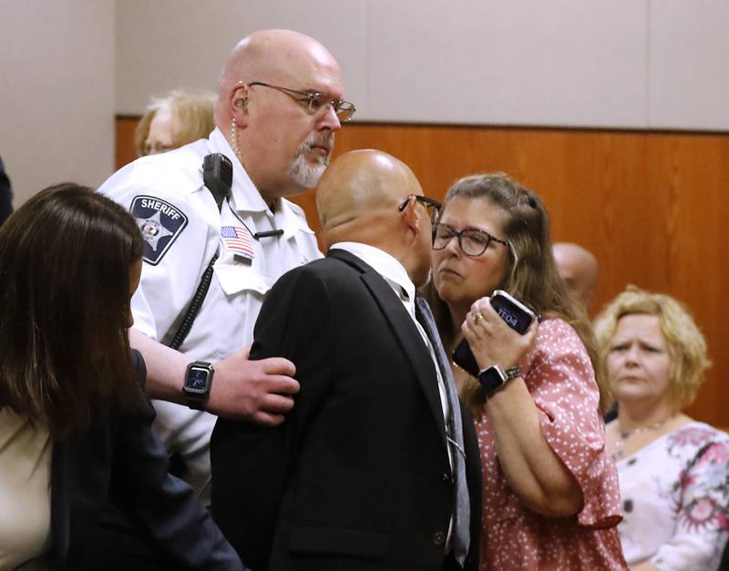 Carlos Acosta tries to kiss his wife, Lori, as he is taken into custody on Thursday, June 6, 2024, after Lake County Judge George Strickland sentenced Acosta, a former Illinois Department of Children and Family Services employee, who was found criminally guilty for mishandling the case of AJ Freund before the Crystal Lake boy was killed by his mother, to six months in jail and 30 months of probation. I Like this photo because of the human elements that are shown.