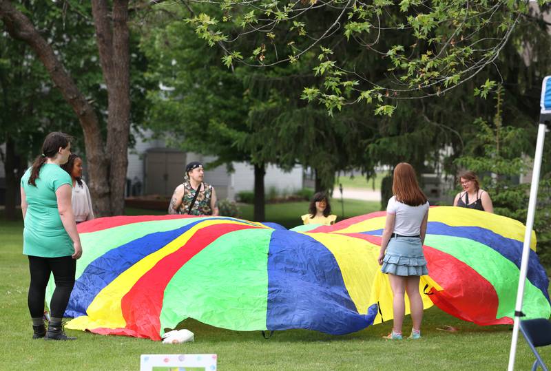A group plays with a parachute during the Pride Palooza Friday, May 30, 2025, at Bethlehem Lutheran Church in DeKalb. The event was hosted by Family Service Agency of DeKalb County and Youth Outlook.