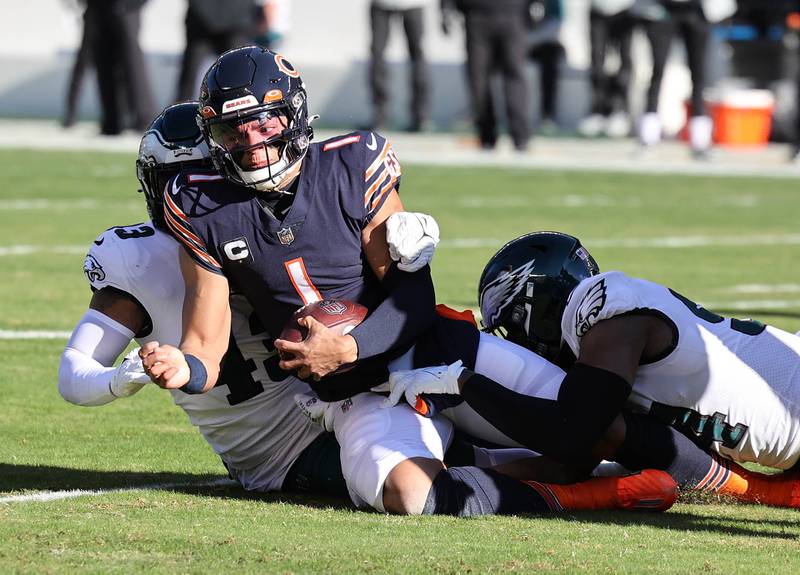 Chicago Bears quarterback Justin Fields is brought down by a pair of Eagles defenders during their game Sunday, Dec. 18, 2022, at Soldier Field in Chicago.