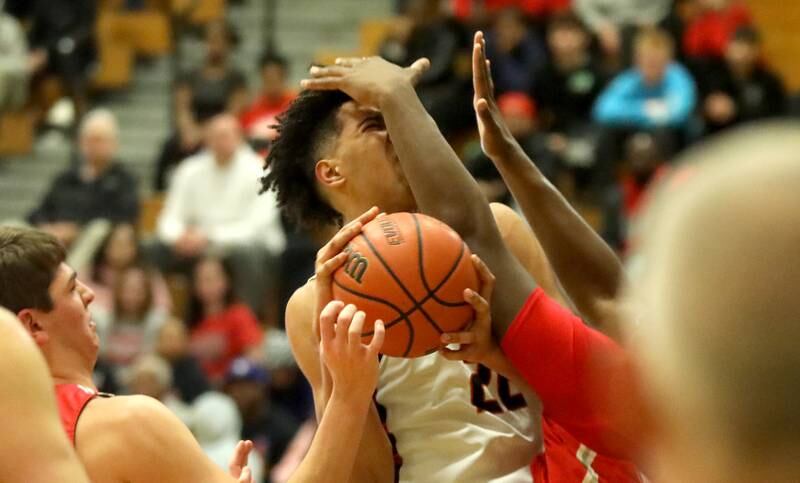 Bolingbrook’s JT Pettigrew gets an arm to the face on his way to the basket during the Jack Tosh Holiday Classic semifinals against Palatine at York High School in Elmhurst on Friday, Dec. 29, 2023.