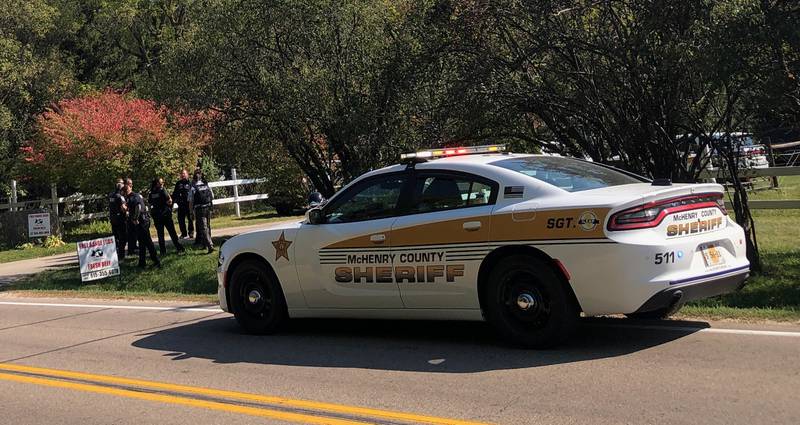 Law enforcement officials stand outside a residence in the Wonder Lake area on Oct. 10, 2024, where authorities warned of a heavy police presence.