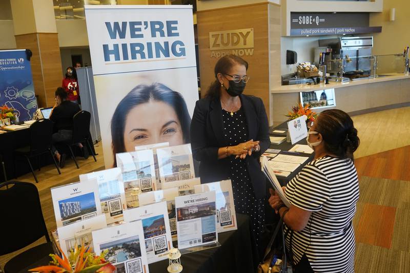 FILE - Marriott human resources recruiter Mariela Cuevas, left, talks to Lisbet Oliveros, during a job fair at Hard Rock Stadium, Friday, Sept. 3, 2021, in Miami Gardens, Fla.  Last month, U.S. employers might have shed jobs for the first time in about a year, potentially raising alarms about the economy’s trajectory. Yet even if the January employment report coming Friday, Feb. 3, 2022, were to show a deep loss of jobs, there would be little mystery about the likely culprit: A wave of omicron wave of infections that led millions of workers to stay home sick, discouraged consumers from venturing out to spend and likely froze hiring at many companies — even those that want to fill jobs.  (AP Photo/Marta Lavandier, File)