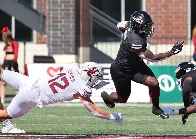 Northern Illinois' Antario Brown is tripped up by Southern Illinois’ Branson Combs during their game Saturday, Sept. 9, 2023, in Huskie Stadium at NIU in DeKalb.
