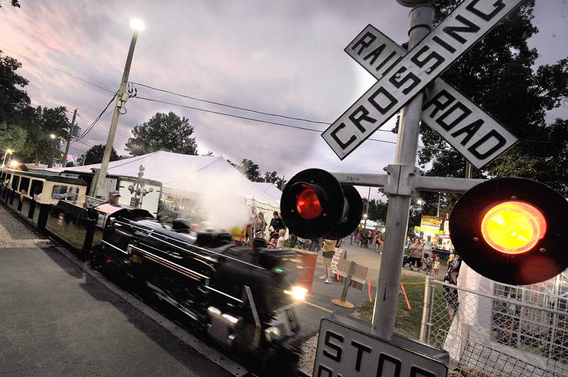The miniature steam engine crosses a fairgrounds pedestrian crossing on Thursday, Sept. 5, 2024, at the Sandwich Fair.