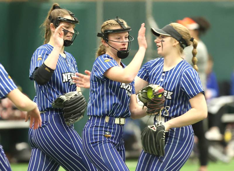 Newark pitcher Taylor Kruser (center) is congratulated by her teammates after a strikeout during their game against DeKalb Thursday, March 31, 2022, at the DeKalb Park District Sports and Recreation Center.