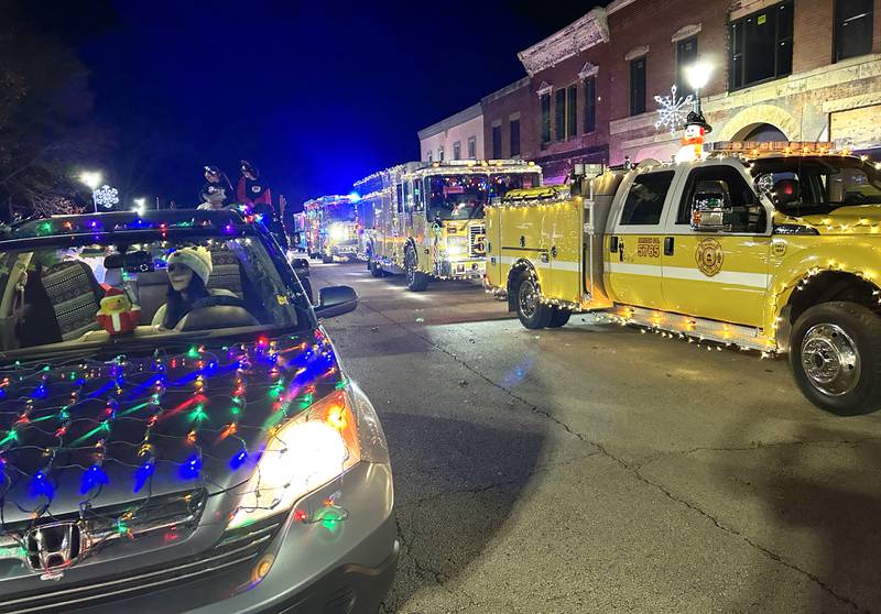Decorated vehicles and Mt. Morris fire engines and trucks lined up on Wesley Ave. during the lighted parade at Mt. Morris' Christmas in the Village on Saturday, Dec. 7, 2024.