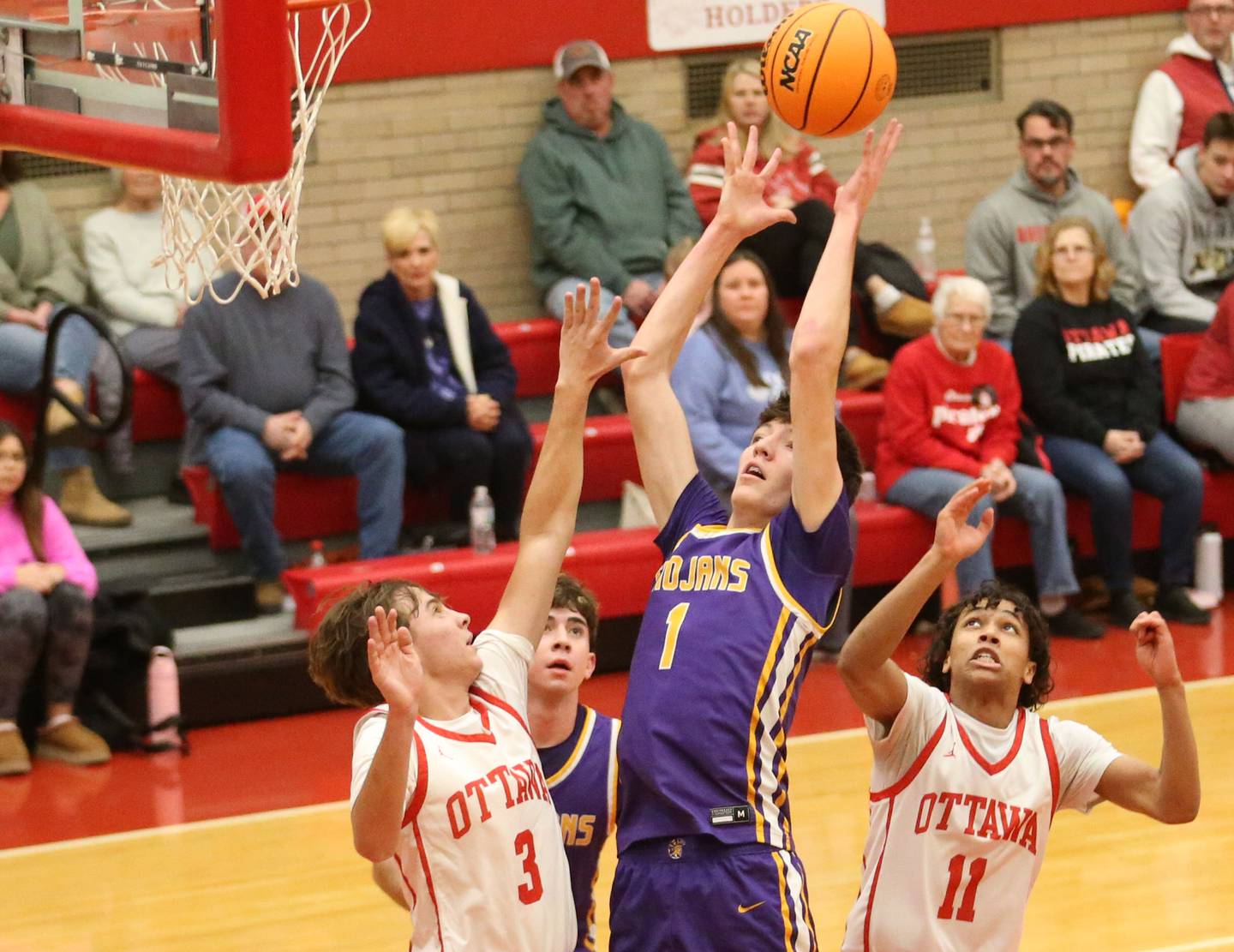Mendota's Cole Tillman grabs a rebound over Ottawa's Connor Diederich and Ottawa Hezekiah Joachim on Tuesday, Jan. 7, 2025 in Kingman Gym at Ottawa High School.