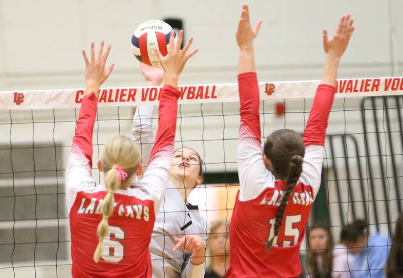 Kaneland's Brielle Gadomski has her spike blocked by L-P's Maggie Boudreau and teakmmate Drew Depenbrock on Tuesday, Oct. 7, 2025 in Sellett Gymnasium at L-P High School.