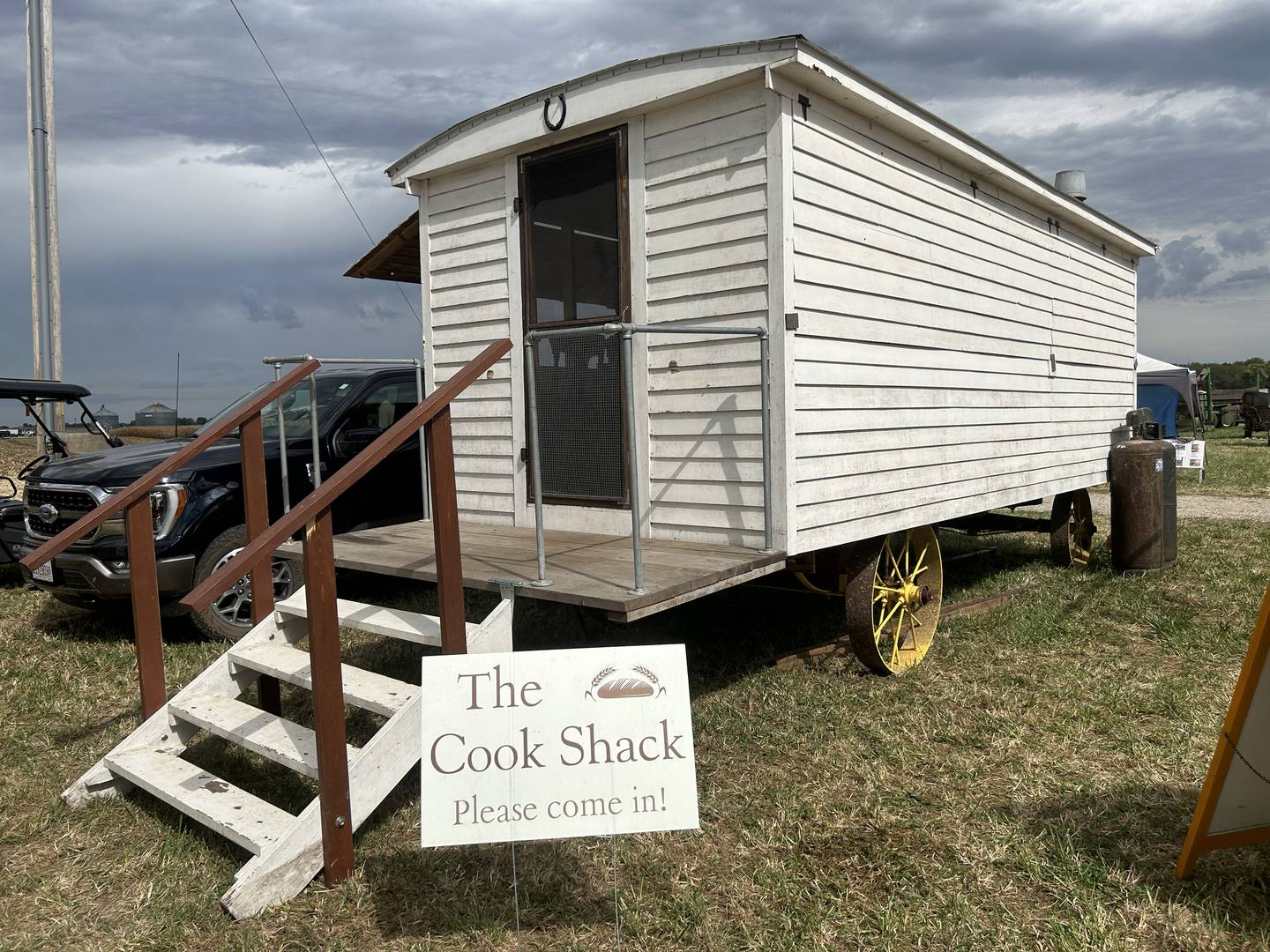 The  "Cook Shack" at the Bos Bros. Historical Farm is where freshly harvested and ground wheat will be transformed into wheat bread during the 2025 Old Fashioned Threshing Bee July 25-27. The wooden shack, mounted on wheels, was pulled to threshing sites so workers could eat during threshing sessions without having to leave the field.