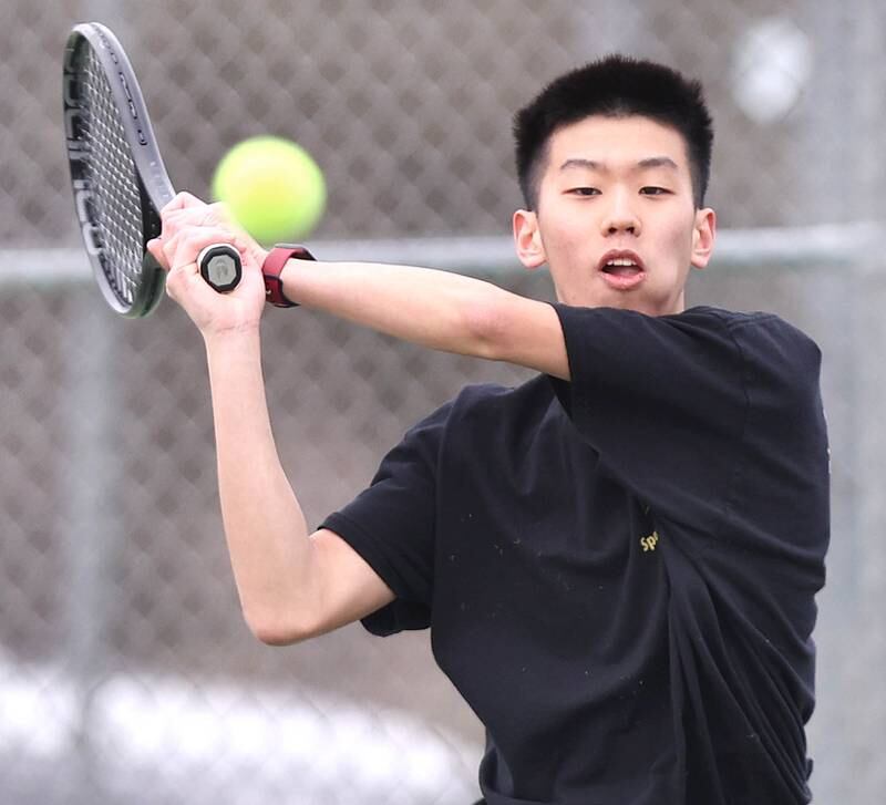 Sycamore’s number one singles player Steven Chen follows through on his backhand during his match against Dixon Thursday, March 30, 2023, at Sycamore High School. This is the inaugural season for the Sycamore boys tennis team.