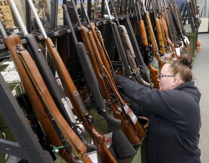 Marissa Drake, a salesperson at Marengo Guns, puts a gun on a gun rack the afternoon of Wednesday, Jan. 18, 2023, at Marengo Guns. The McHenry County gun shop is among a group of plaintiffs challenging the constitutionality of Illinois’ ban on semiautomatic weapons and large-capacity magazines that took effect last week.