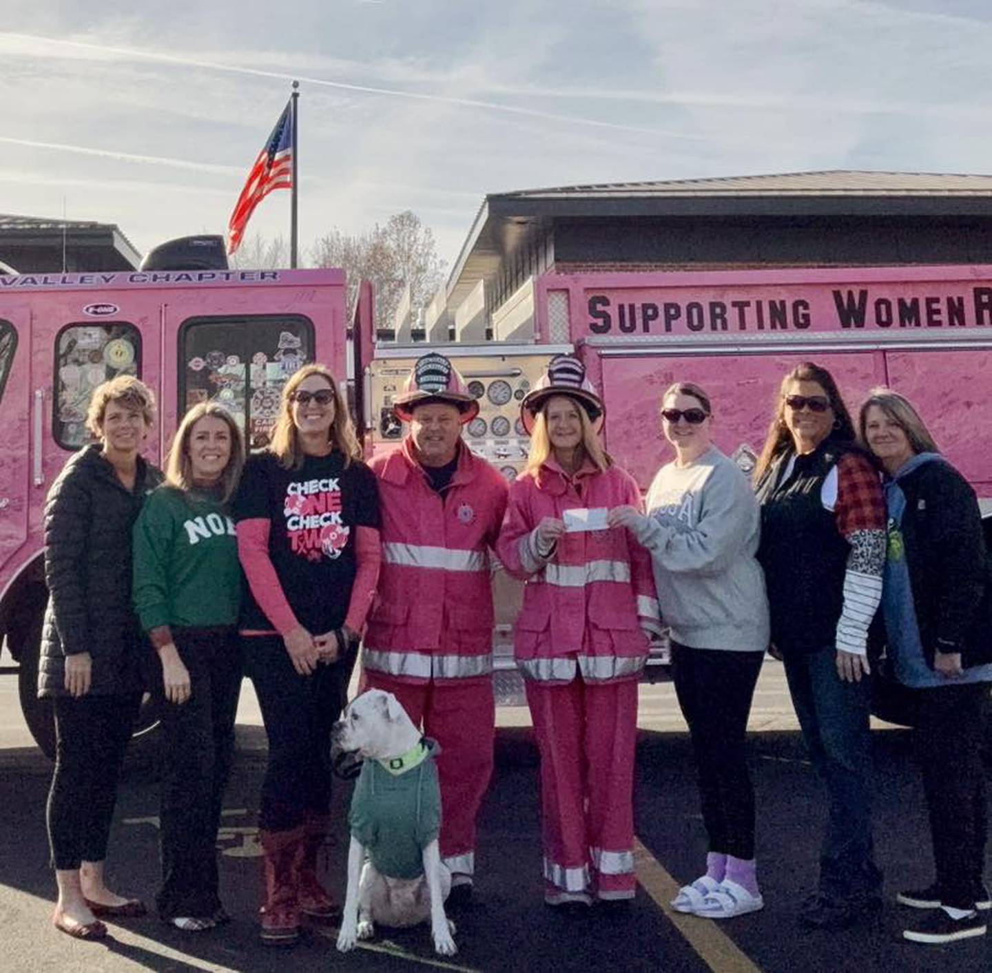 Members of the Department of Fun met up with the Pink Heals Firetruck for a check presentation. Pictured (from left) are Carrie Melton, Elizabeth Yaklich, Amanda Cook (and Bruno), Jenny Patton (third from right), Kelly McDonnell (second from right) and Lisa Vanderlaan (right).