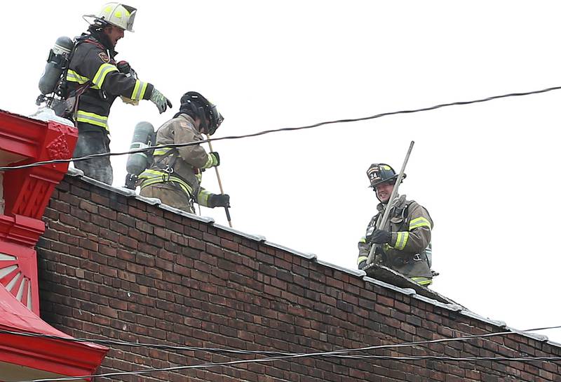 Firefighters remove debris off of the rooftop of a structure fire at 201 North Main Street on Monday, Aug. 14, 2023 at Ladd. The fire happened just before 7:30a.m. and was upgraded to a three-alarm fire.  Firefighters from Mendota, Ladd, Peru, La Salle, Utica, Princeton and others helped with the blaze.