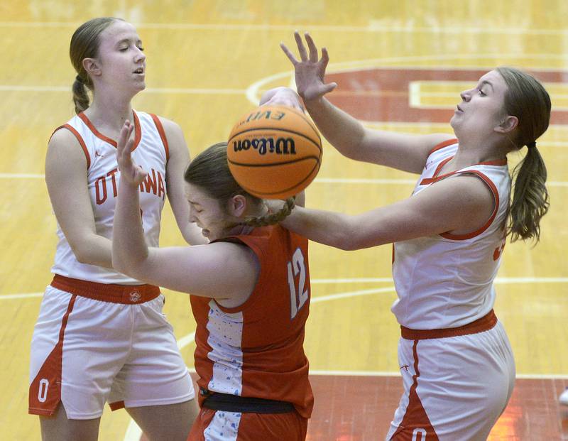 Ottawa’s Skylar Dorsey and Charley Maierhofer battle Streator’s Keah Krohe for a rebound in the 2nd period Thursday at Ottawa.