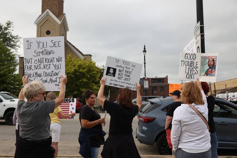 Protesters hold signs in reference to the late civil rights leader and congressman John Lewis during a "Good Trouble Lives On" rally held in Kankakee as part of a national day of peaceful protests on Thursday, July 17, 2025.