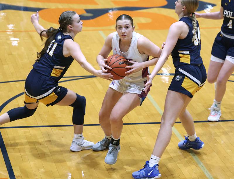Genoa-Kingston's Ally Poegel drives between Polo's Courtney Grobe (left) and Syndei Rahn during their game Monday, Jan. 29, 2024, at Genoa-Kingston High School.