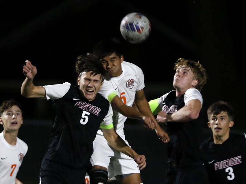 Crystal Lake Central's Elder Hernandez tries to head the ball into the goal between Prairie Ridge's Brandon Matei (left) and Seth Matson (right) during the IHSA Boys Soccer 2A Grayslake Central Sectional semifinal match on Tuesday, Oct. 29, 2024, at Grayslake Central High School,