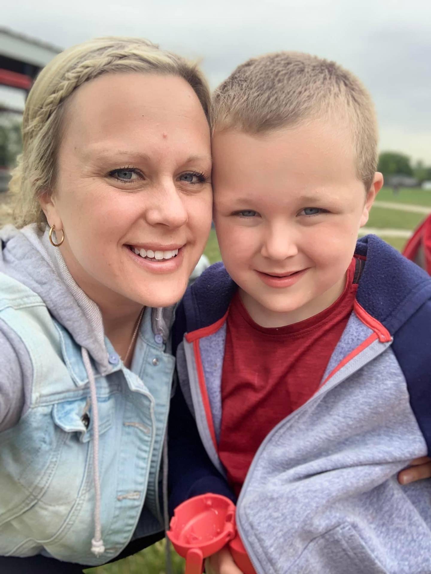 Alan Maziur, 7, and son his mother Jenna Maziur, a girls basketball coach at Providence Catholic High School, smile for the camera. Alan has nonverbal autism and loves basketball. He will participate in a basketball camp for students with special needs in January 2023. Jenna will help run it.