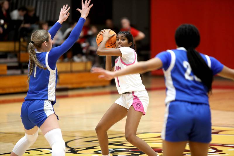 Batavia’s Julia Arulandu passes the ball through a pair of Wheaton North defenders during a game on Wednesday, Jan. 29, 2025 at Batavia.