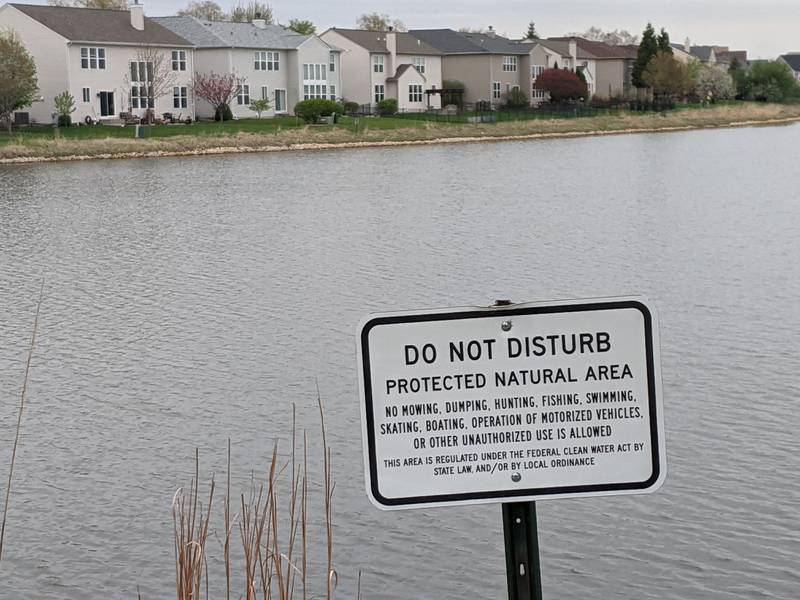 A sign in Prescott Mill subdivision in Oswego states that a pond is a protected natural area and no fishing is allowed. Those people who choose to fish in ponds owned by homeowners associations in Oswego that don’t allow fishing in their ponds can now be ticketed.